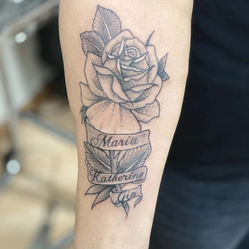 Rose With Name Tattoo On Arm Black Design